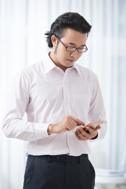 Modern ethnic businessman using smartphone