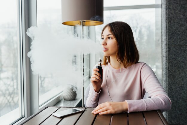 Modern girl smoking vape.