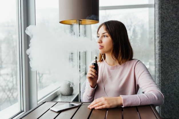 Modern girl smoking vape.