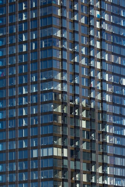 Modern glass skyscraper background with sky and clouds reflection