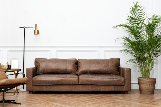 Современный индустриальный интерьер гостиной в роскошном стиле с кожаным диваном, золотой лампой и комнатными растениями