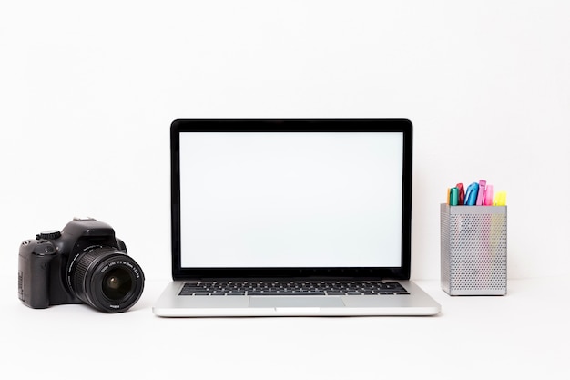 Modern laptop and camera on white background