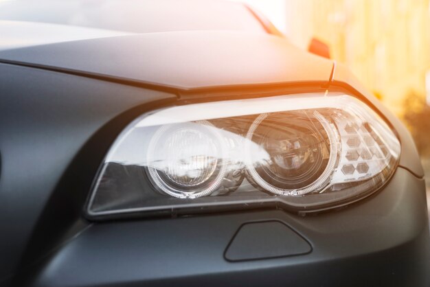 Modern led headlight of dark car on street