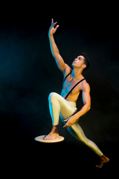 Foto gratuita esecutore di balletto maschio moderno danza sotto i riflettori