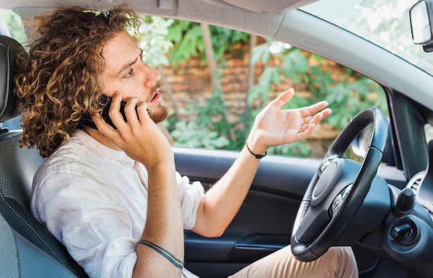 Modern man making phone call in car