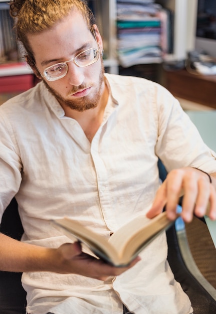 Foto gratuita uomo moderno che legge sul divano