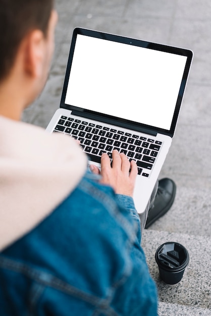 Modern man using laptop in urban environment