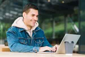 Free photo modern man using laptop in urban environment