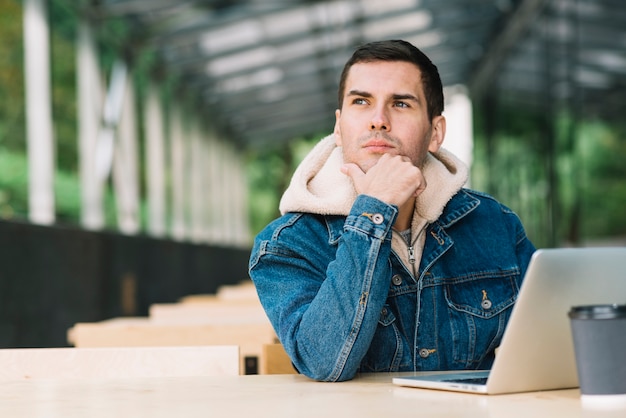 Modern man using laptop in urban environment