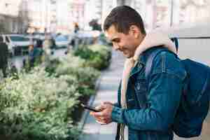 Free photo modern man using smartphone in city