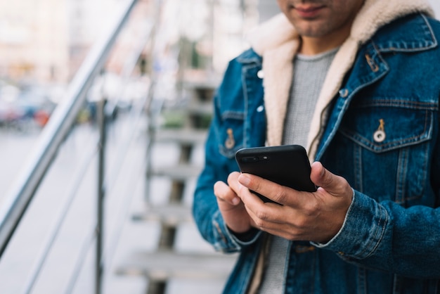 Modern man using smartphone in city