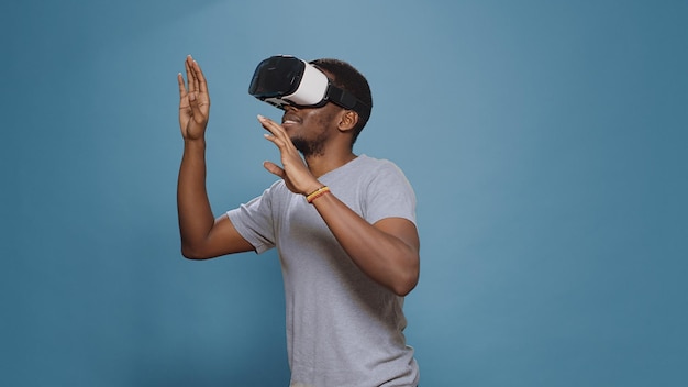 Modern man using vr glasses with futuristic augumented software, enjoying interactive vision on virtual reality headset. Cheerful person having fun with digital goggles, visual innovation game.