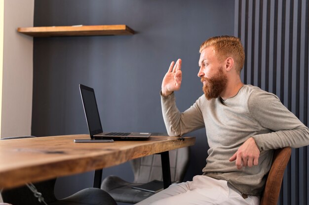 Modern man waving while having a videocall