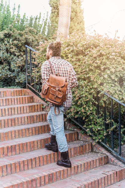 Modern man with bag going upstairs