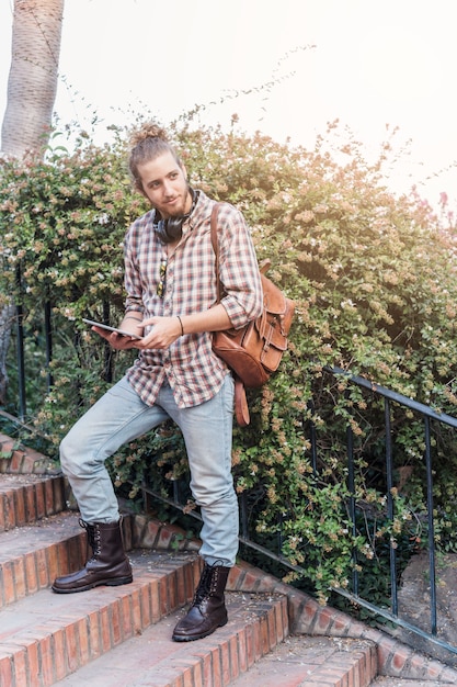 Modern man with bag and tablet on stairs