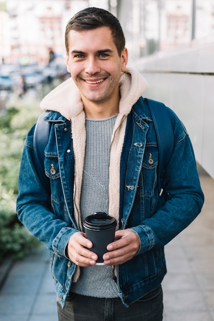 Современный человек с чашкой кофе в городской среде
