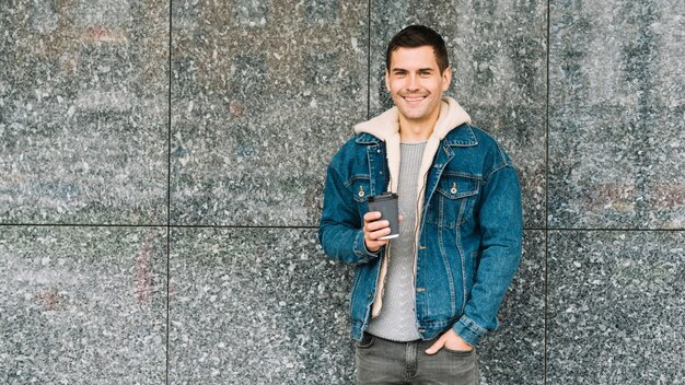 Modern man with coffee cup in urban environment