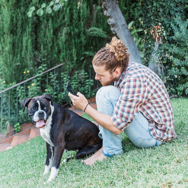 Foto gratuita uomo moderno con cane in giardino