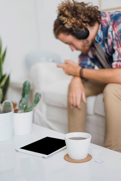 Modern man with smartphone on couch