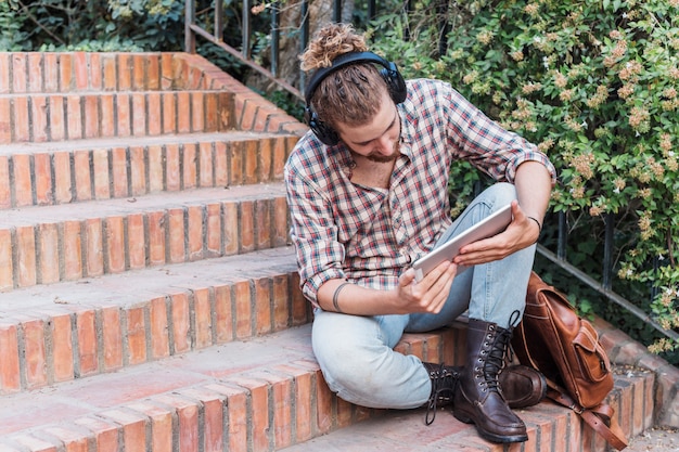 Free photo modern man with tablet on stairs