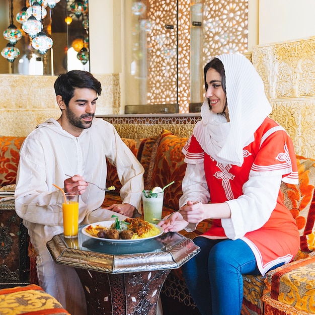 Modern muslim couple in restaurant