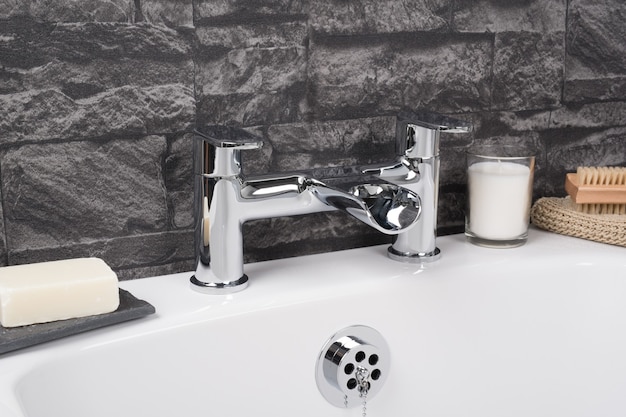 Modern and new steel faucet with the ceramic bathtub  in the bathroom