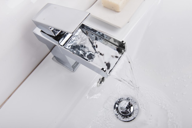 Modern and new steel faucet with the ceramic bathtub in the bathroom