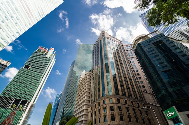 Современное офисное корпоративное здание. Взгляд низкого угла небоскребов в городе Сингапура. Панорамный и перспективный взгляд Концепция дела архитектуры техника индустрии успеха.