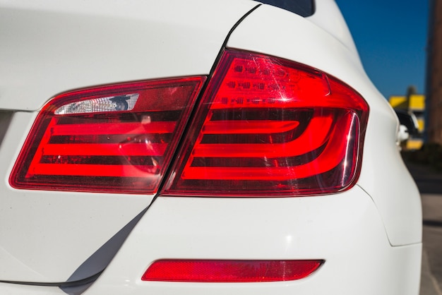 Modern rear light on new white automobile on street 