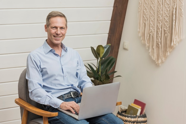 Modern senior man holding a laptop