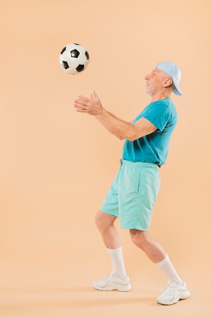 Современный старший мужчина с футболом