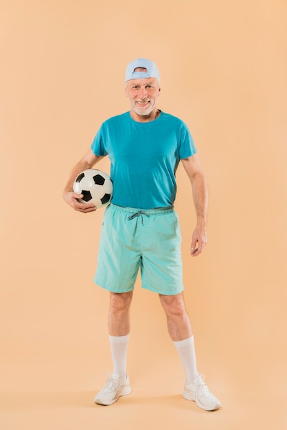 Бесплатное фото Современный старший мужчина с футболом