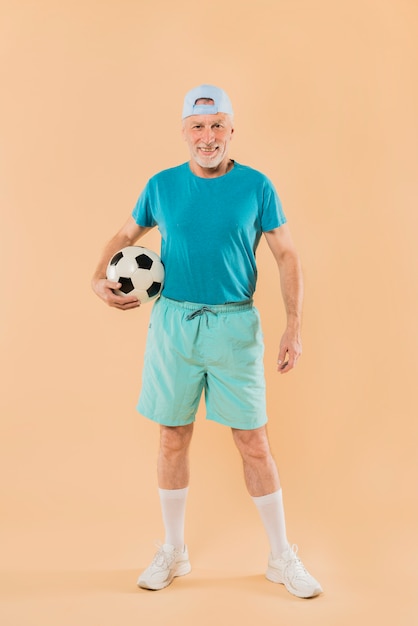 Modern senior man with football