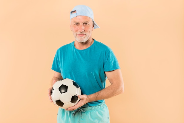 Modern senior man with football