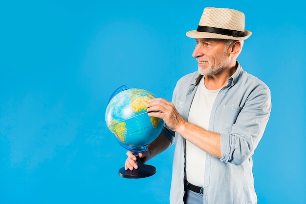 Modern senior man with globe