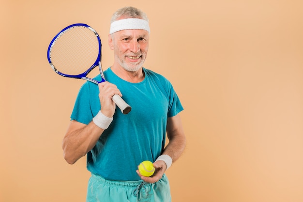 Современный старший мужчина с теннисной ракеткой