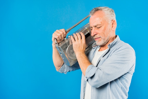 Modern senior man with vintage radio