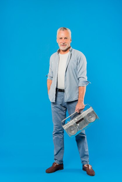 Modern senior man with vintage radio