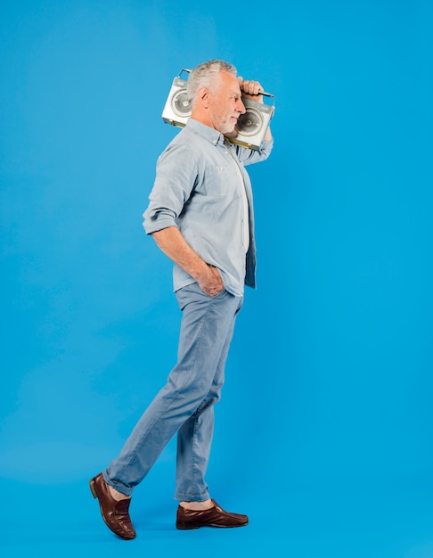 Modern senior man with vintage radio