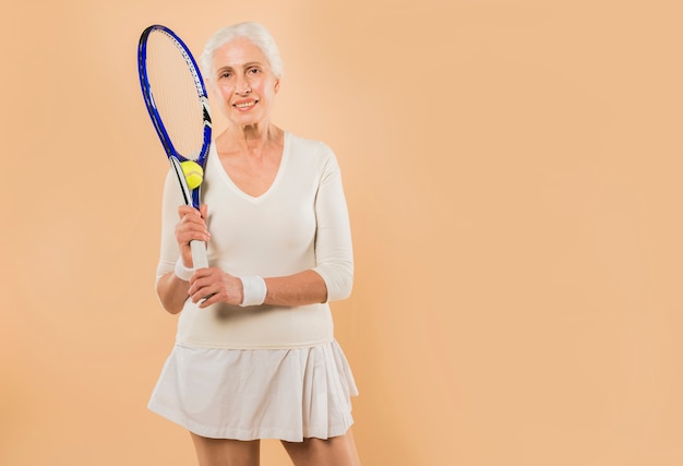 Modern senior woman playing tennis