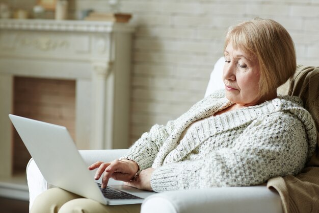 Modern senior woman surfing the net