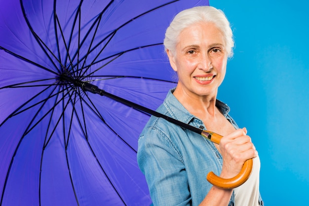 Foto gratuita donna senior moderna con l'ombrello
