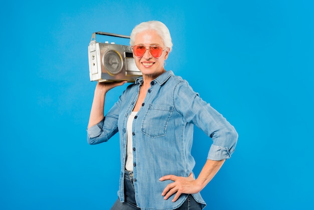 Free photo modern senior woman with vintage radio