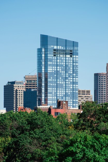 Modern skyscraper with glass facade and greenery around