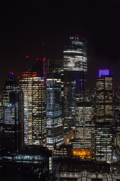 ロンドンの夜空の下でライトとモダンな高層ビル