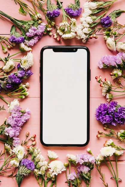 Modern smartphone and arranged flowers