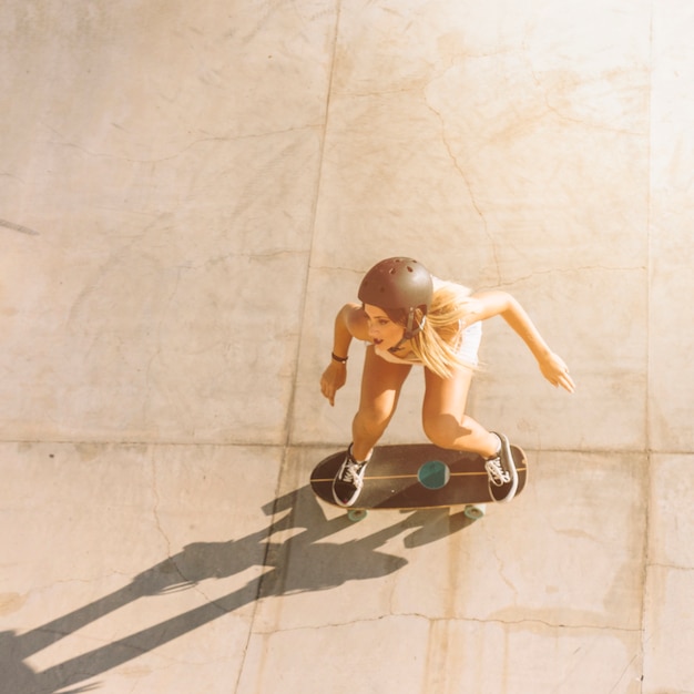 Free photo modern sporty girl skating in half pipe