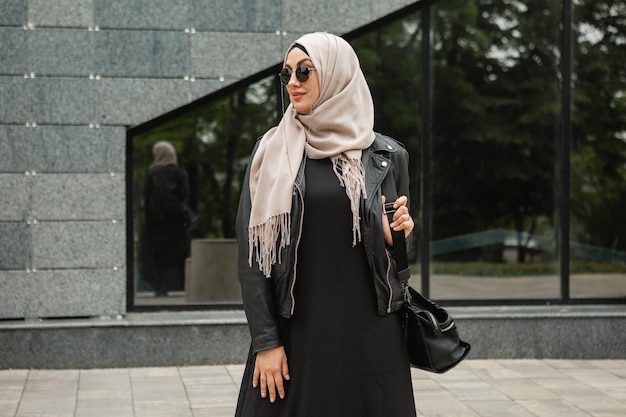 Modern stylish muslim woman in hijab in city street
