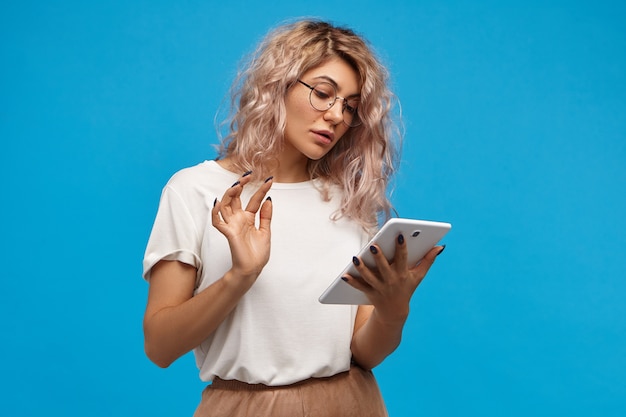 modern technology, electronic gadgets, devices and lifestyle concept. portrait of fashionable hipster girl using high speed wi fi on digital tablet, shopping online