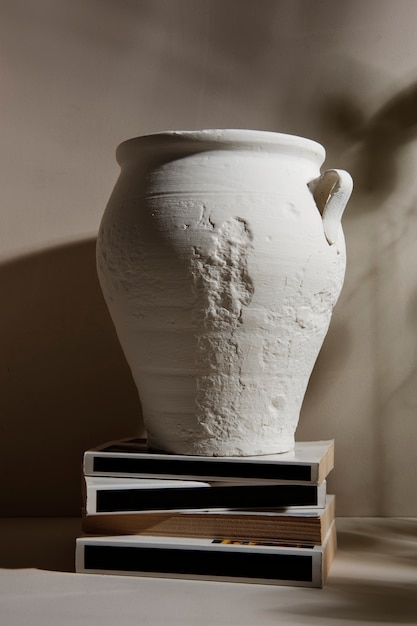 Free photo modern white vase and books arrangement